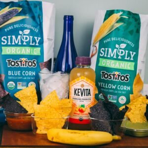 A colorful assortment of organic snacks including Tostitos chips and Kevita drink.